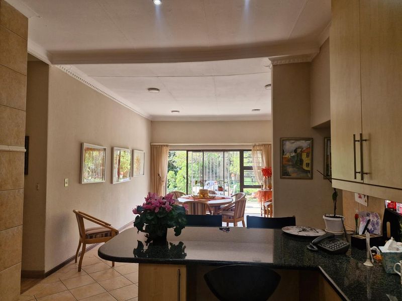 Open plan living and kitchen area featuring granite countertops, tiled flooring, and large sliding doors leading to an outdoor space.