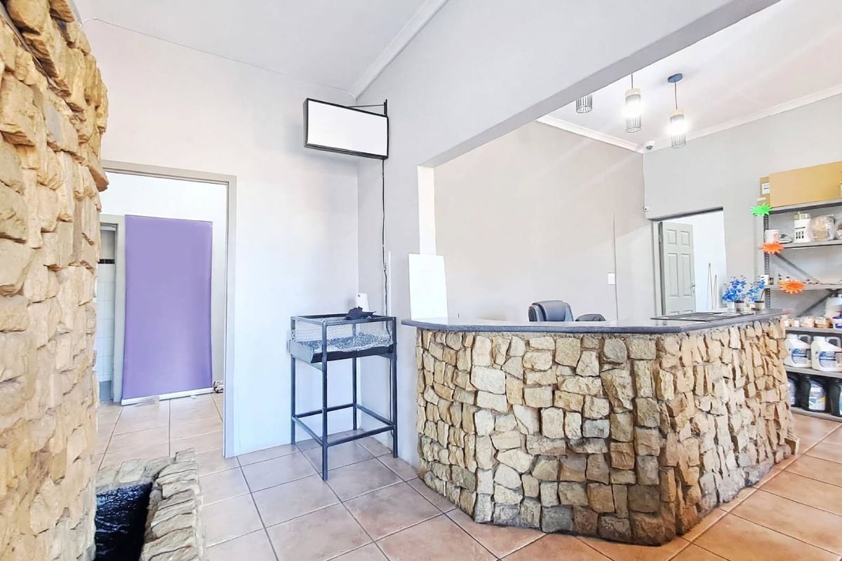 A commercial reception area featuring a stone-clad service counter, tiled flooring, and a decorative stone feature wall, providing a rustic professional entrance.