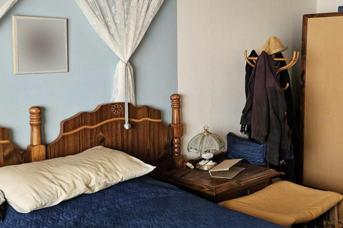 A bedroom featuring a wooden bed frame and a built-in wardrobe, with a two-tone wall finish.