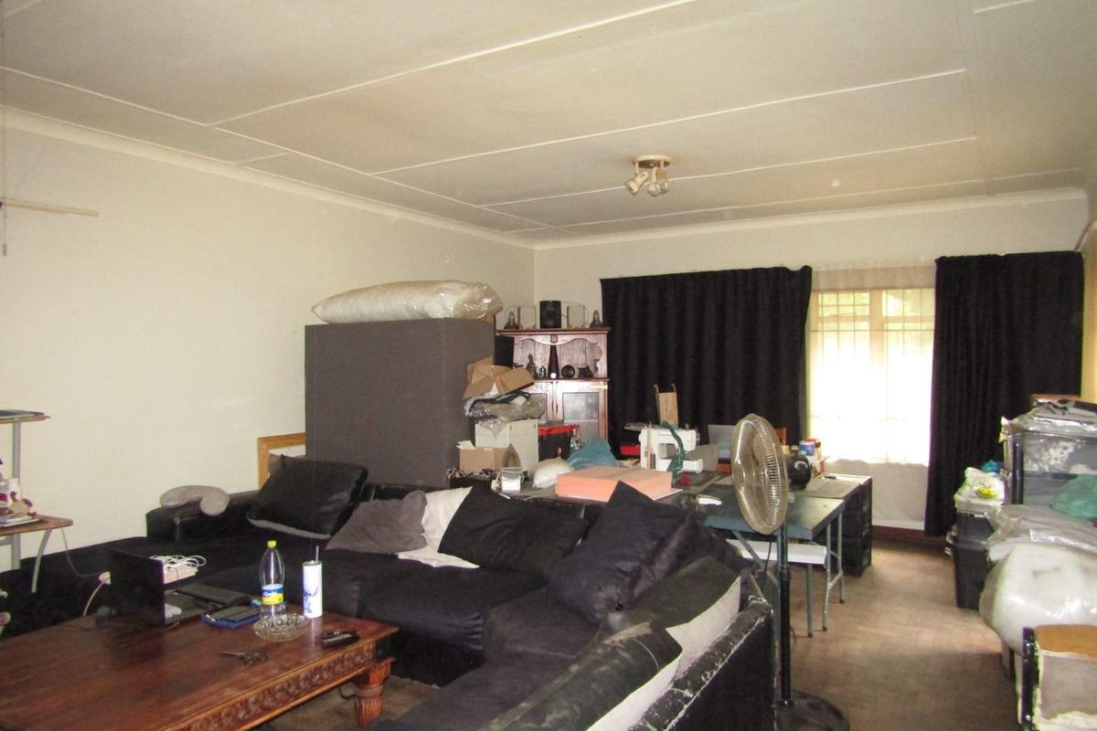 A spacious living area featuring tiled ceilings and large windows, offering a versatile layout for comfortable family living.