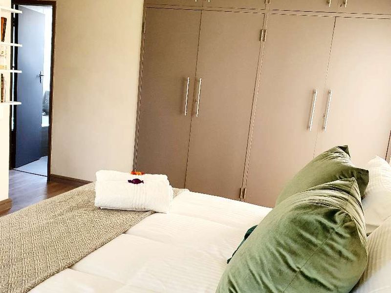 A bedroom featuring built-in floor-to-ceiling cabinetry and a doorway leading to an adjacent room.