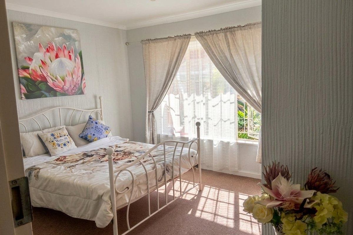 A cozy bedroom featuring carpeted flooring and a window with natural light, providing a comfortable and functional living space.