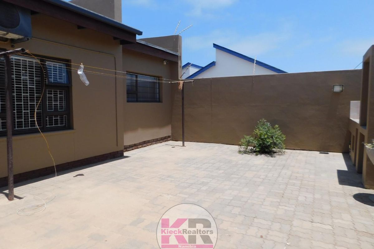 A paved rear courtyard area featuring high boundary walls, providing a private and low-maintenance outdoor space.