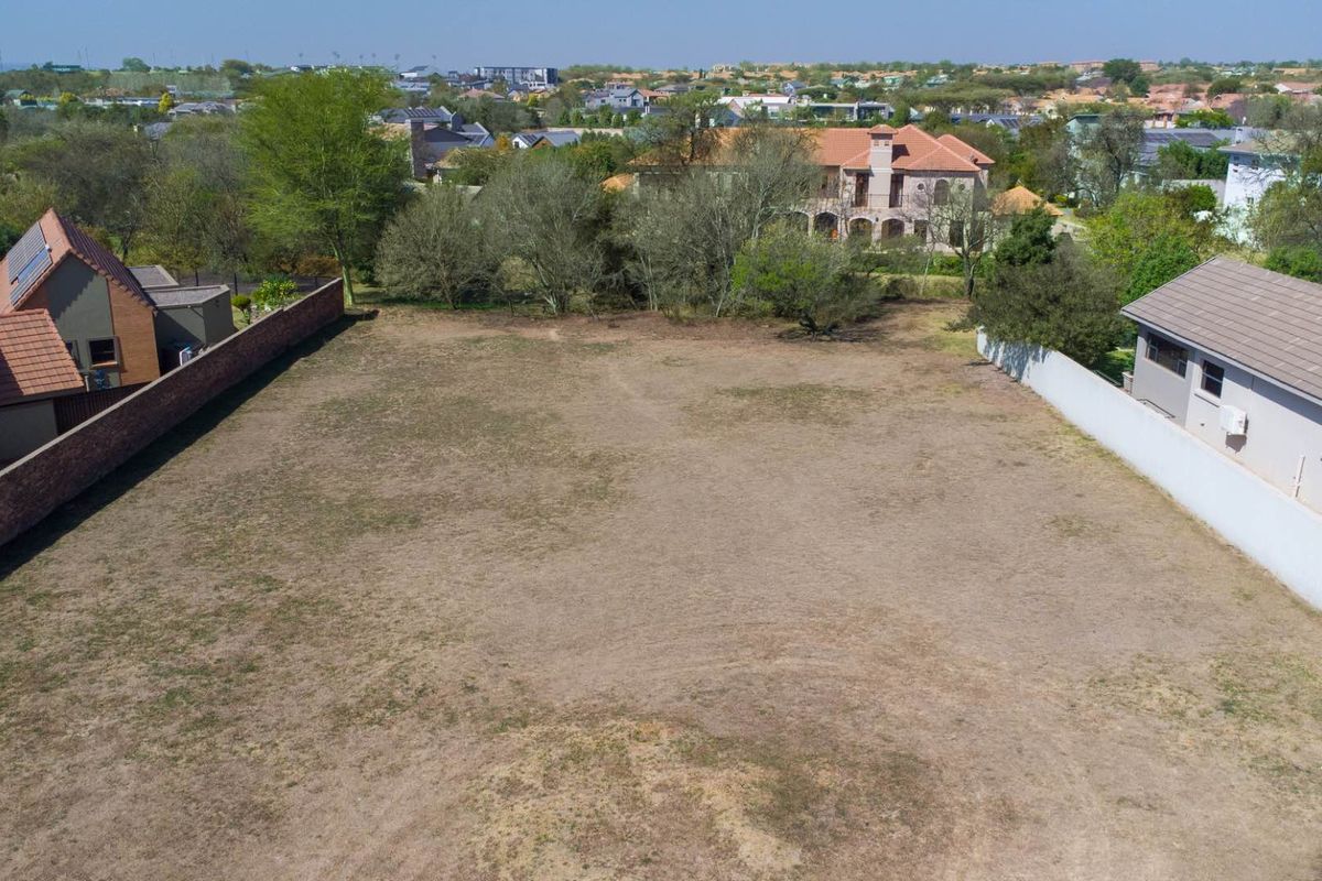 An aerial view of a vacant residential plot, showing clear boundaries and surrounding established neighborhood infrastructure.