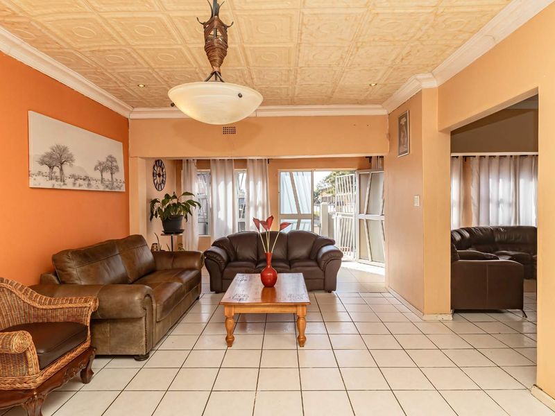 Spacious living area featuring tiled flooring, a textured ceiling, and direct access to the exterior through a sliding glass door.