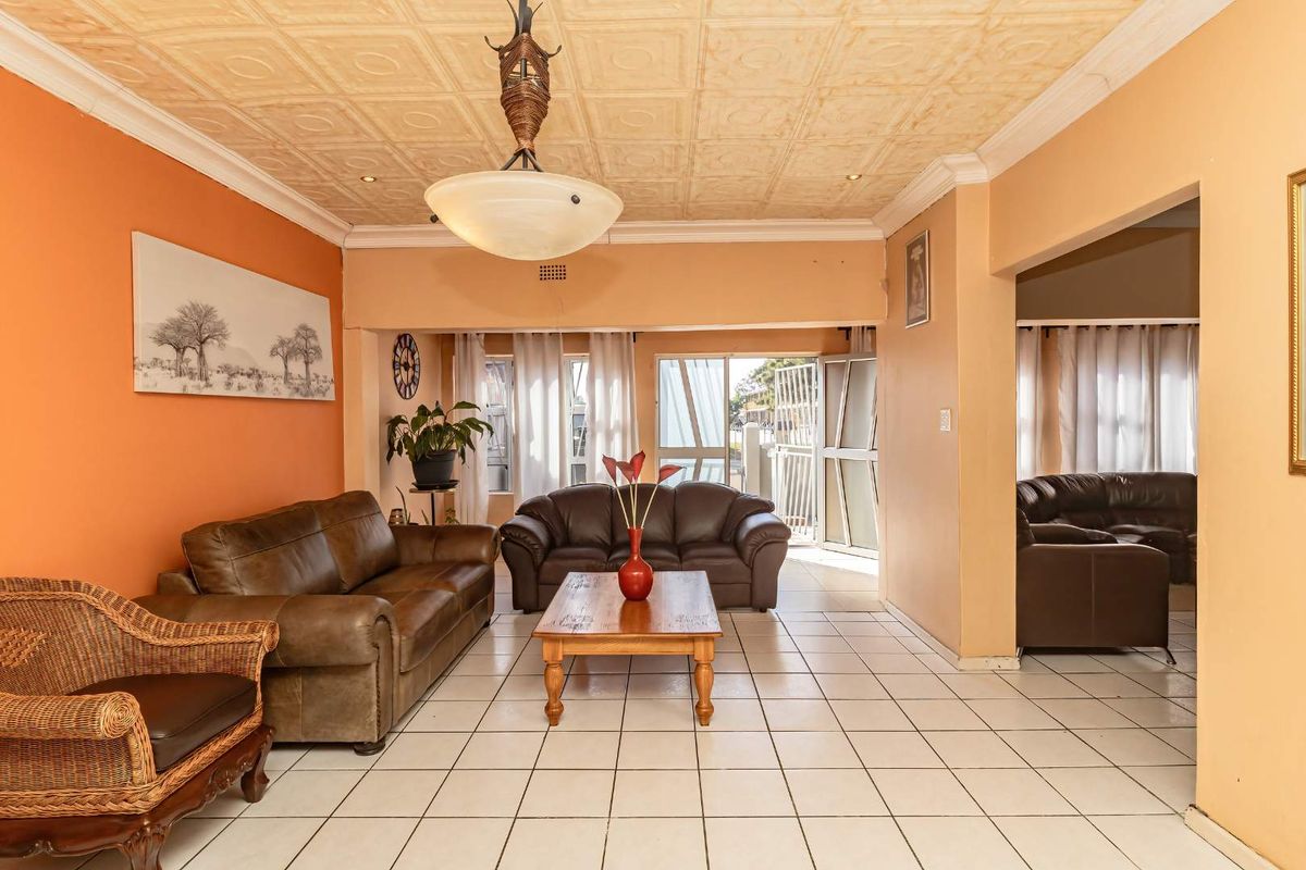 Spacious living area featuring tiled flooring, a textured ceiling, and direct access to the exterior through a sliding glass door.
