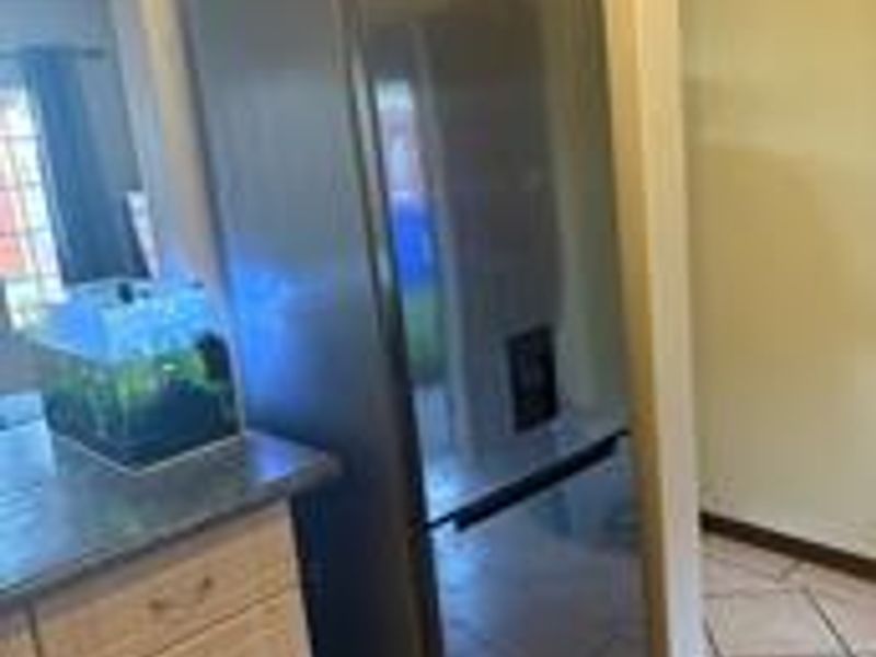 A kitchen area featuring tiled flooring and built-in cabinetry, providing functional storage and workspace within the apartment.