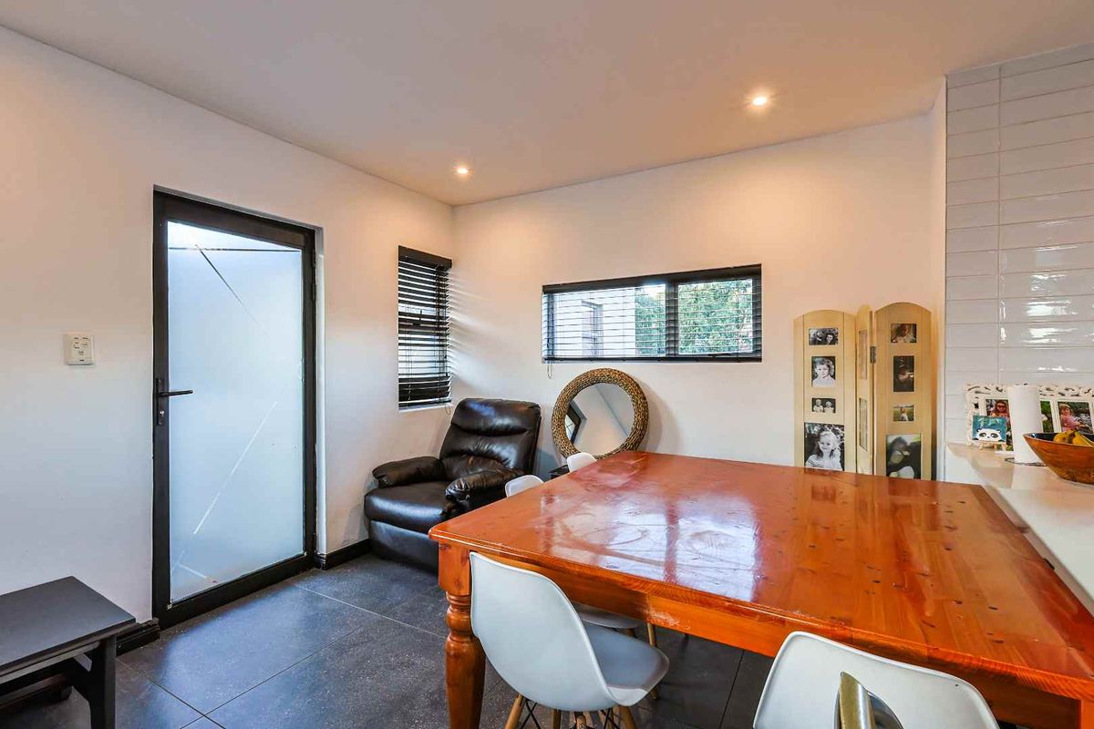 A functional kitchen area featuring tiled flooring, modern recessed lighting, and a glass-paneled exterior door providing natural light.