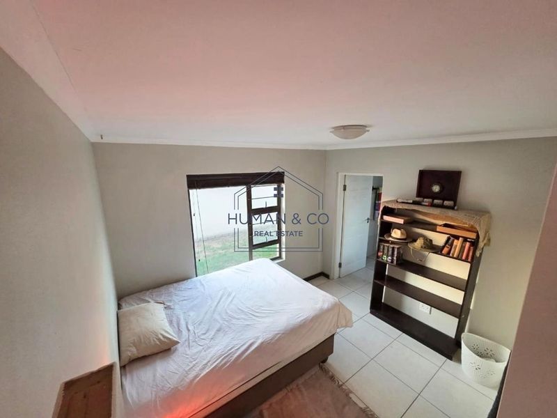 A standard bedroom featuring tiled flooring and a window, providing a functional living space.