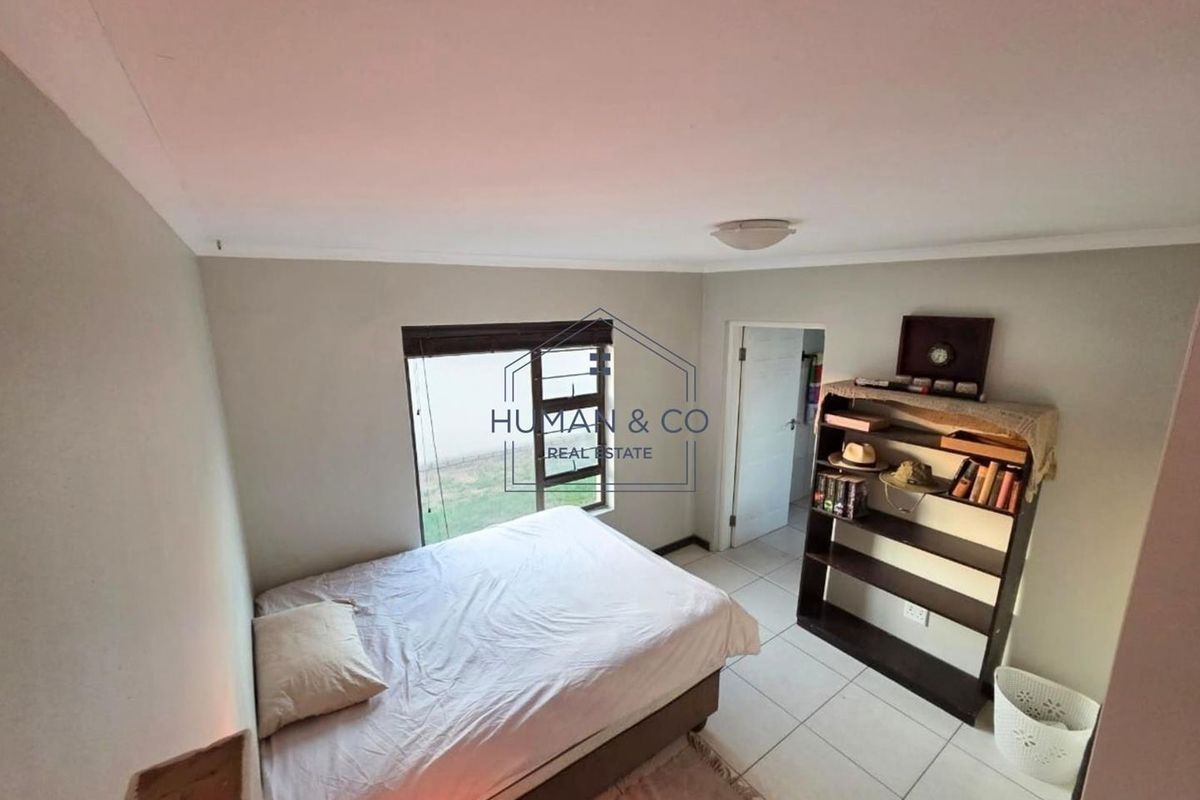 A standard bedroom featuring tiled flooring and a window, providing a functional living space.