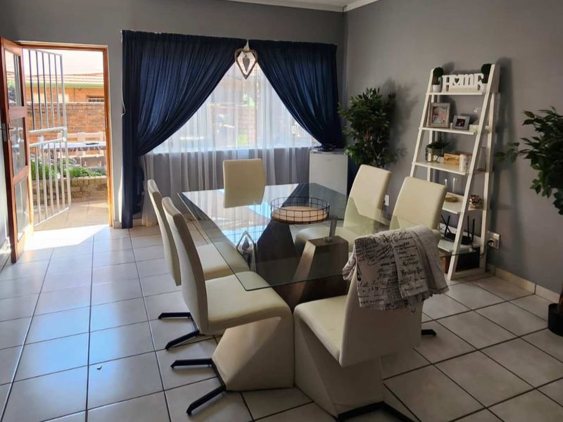 A dining room featuring tiled flooring and direct access to the exterior through a security gate and door.
