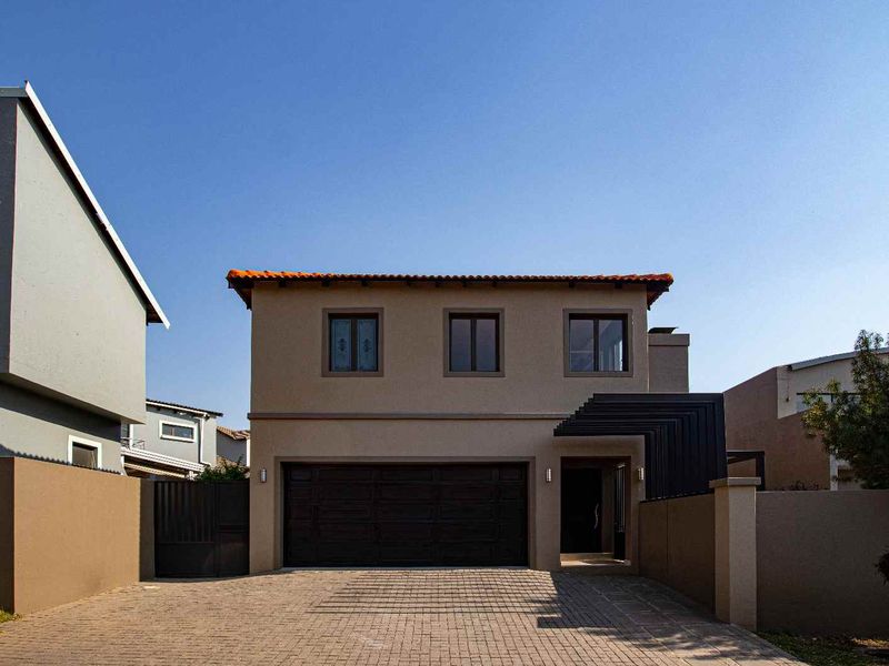 Front elevation of a double-story residence featuring a paved driveway, integrated double garage, and modern entrance canopy.