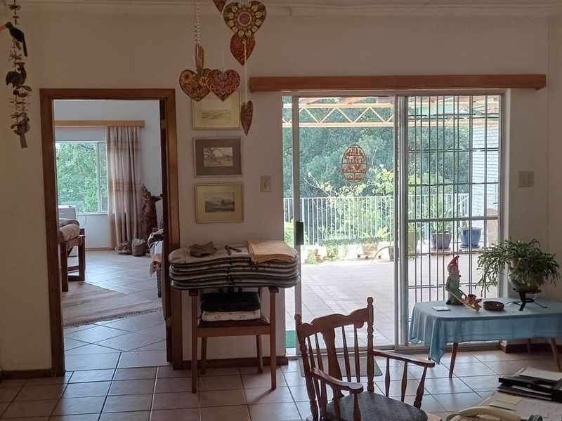 A living area featuring tiled flooring and a sliding glass door providing access to an outdoor patio space.