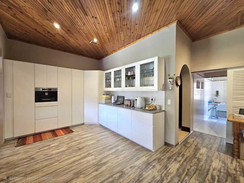 Modern kitchen featuring sleek white cabinetry, built-in oven, and a distinctive timber-clad vaulted ceiling, leading through an archway to an adjacent utility area.
