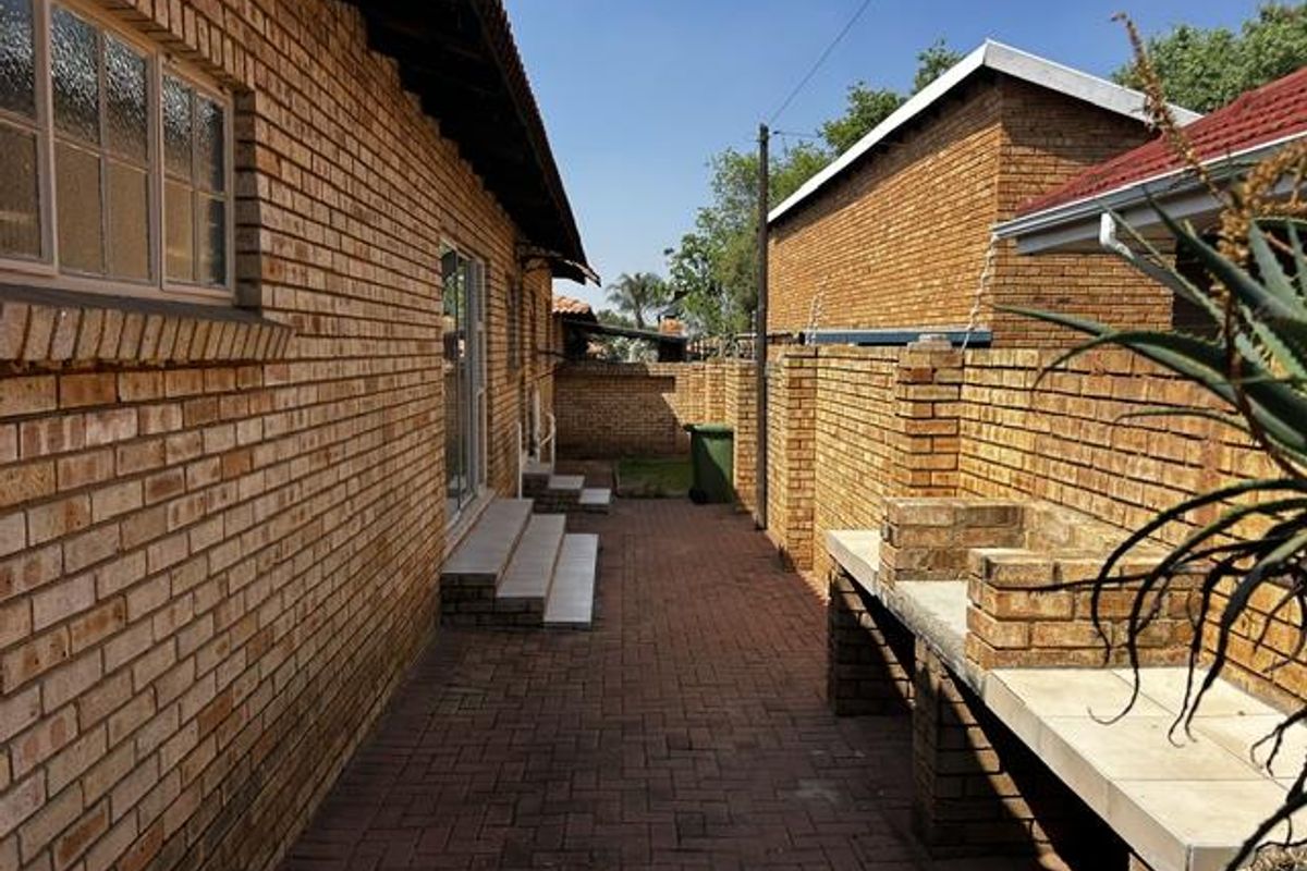 Rear exterior area featuring brick paving, a built-in brick braai, and access to the main dwelling via sliding doors.