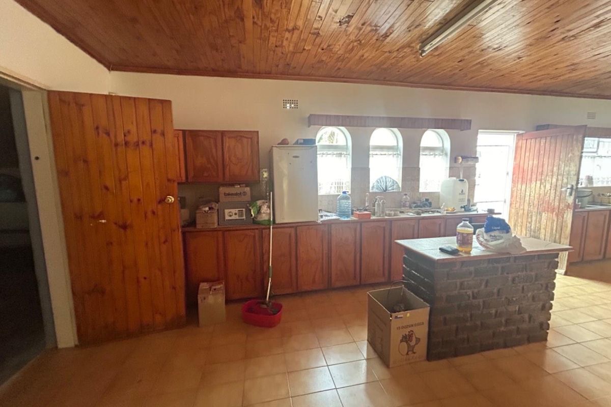 A dated kitchen featuring timber cabinetry, a brick-base island, and a timber-clad ceiling, offering significant potential for a modern renovation.