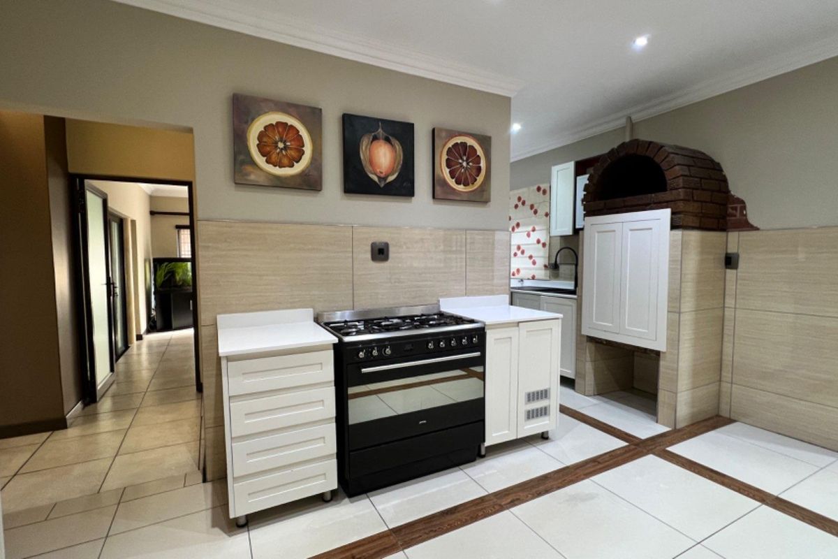 A well-maintained kitchen featuring a built-in gas stove, tiled splashbacks, and a unique integrated brick-arched oven or storage feature.