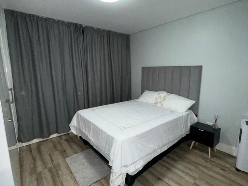 A well-maintained bedroom featuring modern laminate flooring and neutral wall finishes, providing a clean and comfortable living space.