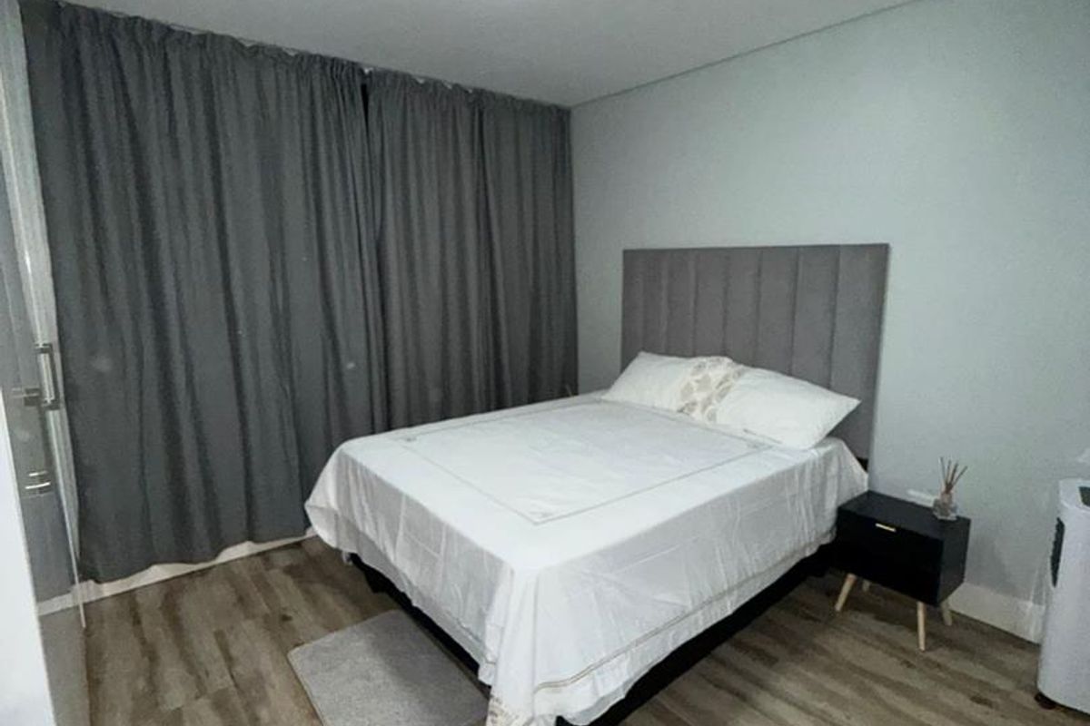 A well-maintained bedroom featuring modern laminate flooring and neutral wall finishes, providing a clean and comfortable living space.
