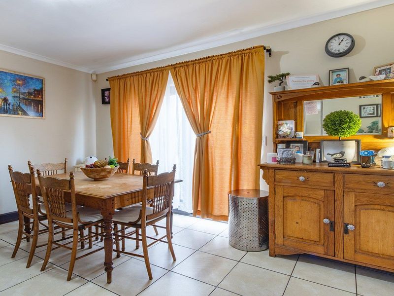 A dining room featuring tiled flooring and a sliding glass door providing access to the exterior.