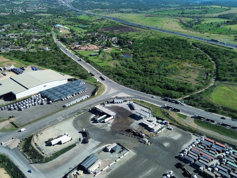 Aerial view of an industrial property featuring a large warehouse, extensive paved yard, fueling infrastructure, and direct access to major transport routes.