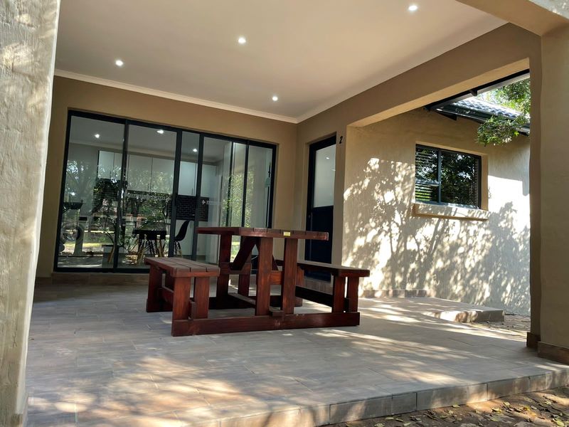 A covered patio area featuring tiled flooring, recessed downlights, and large sliding glass doors providing seamless access to the interior living space.