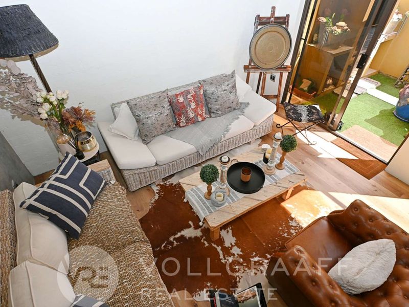 A bright and inviting living room featuring hardwood flooring and a large sliding glass door that provides seamless access to the outdoor area.