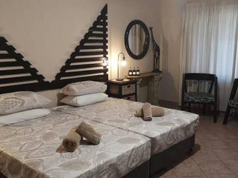 A bedroom featuring tiled flooring and neutral wall tones, providing a functional space with built-in curtain rails.