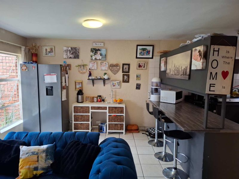 Open plan living area featuring a breakfast bar counter and tiled flooring, providing a functional space for dining and casual seating.