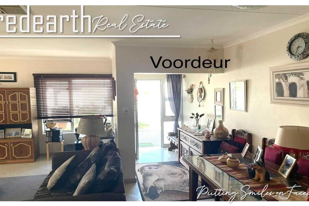 A view of the living area looking towards the front entrance, featuring tiled flooring and natural light from the window.