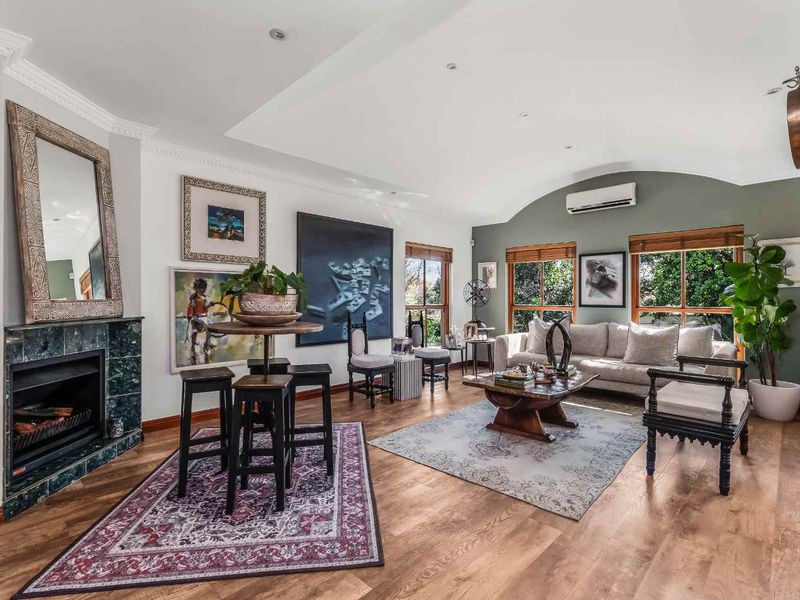 Spacious living room featuring timber flooring, a marble-surround fireplace, recessed lighting, and a split-system air conditioner, offering a comfortable and well-maintained living space.