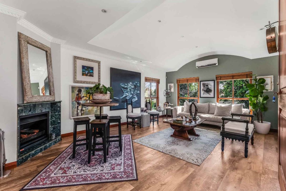 Spacious living room featuring timber flooring, a marble-surround fireplace, recessed lighting, and a split-system air conditioner, offering a comfortable and well-maintained living space.