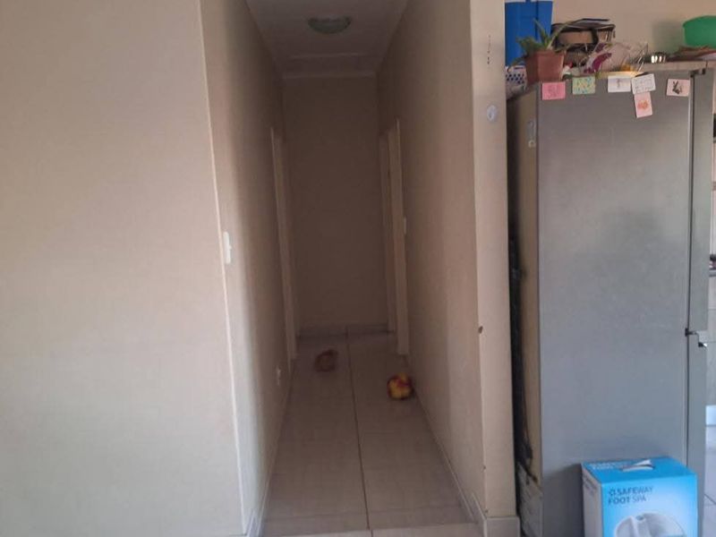 A functional hallway with tiled flooring connecting various rooms within the apartment.