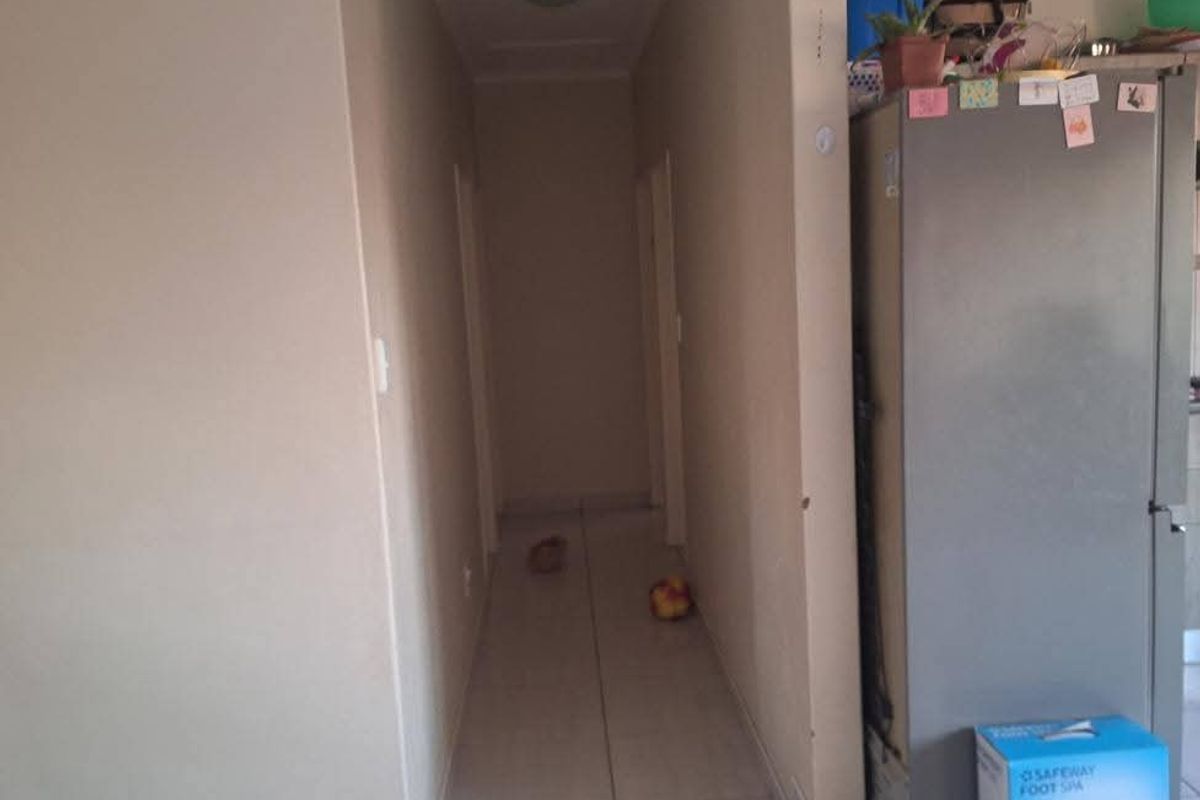 A functional hallway with tiled flooring connecting various rooms within the apartment.