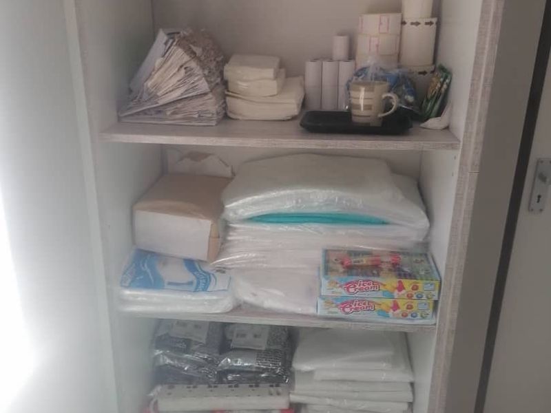 A functional built-in storage shelving unit used for organizing supplies and office materials.