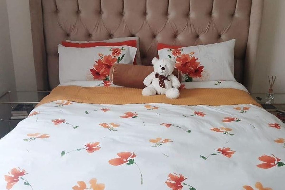 A bedroom featuring a tufted upholstered headboard.