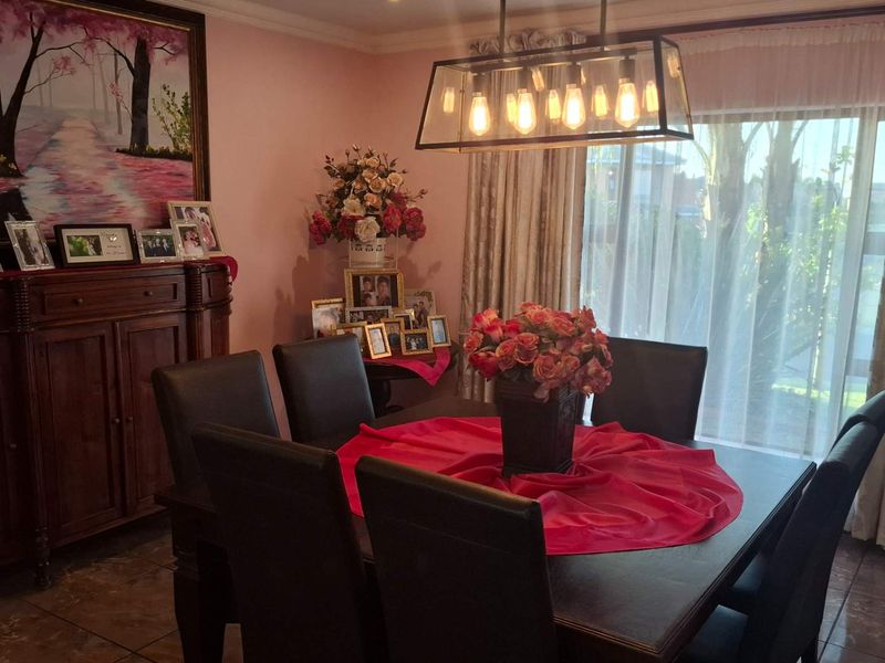 A dining room featuring tiled flooring and a modern pendant light fixture, providing a functional space for meals.