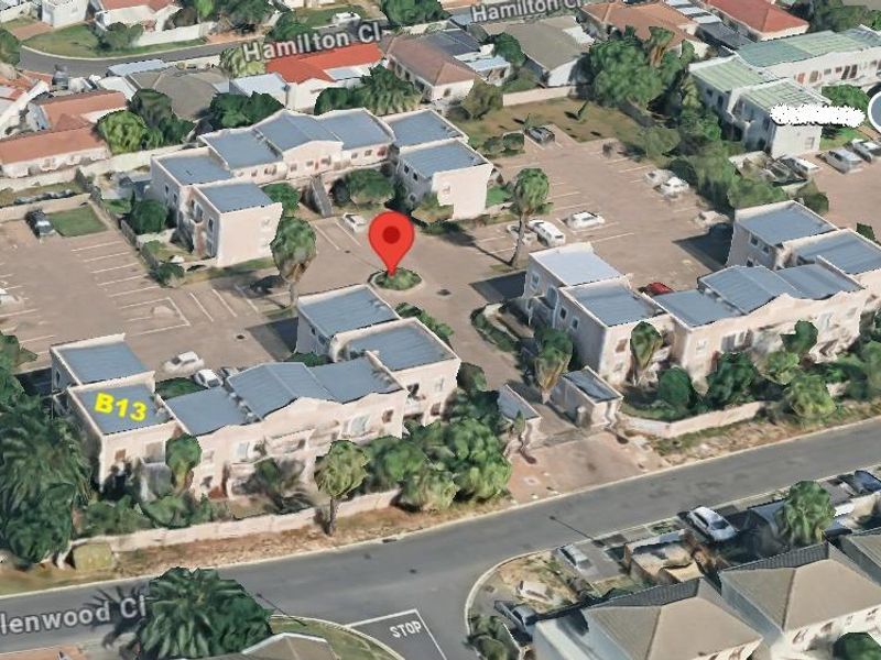 An aerial view of the apartment complex showing the layout of the buildings, parking facilities, and surrounding street access.