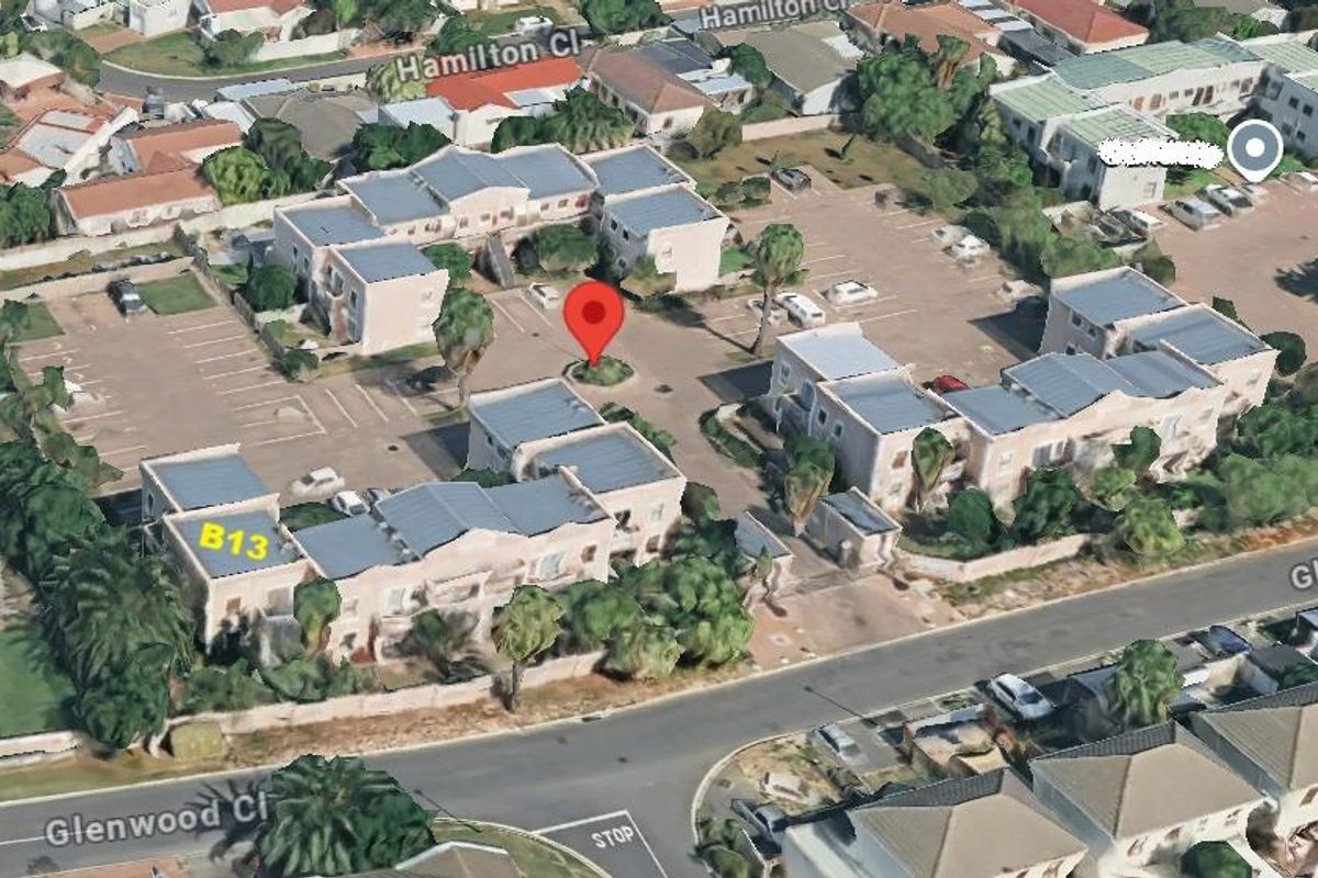 An aerial view of the apartment complex showing the layout of the buildings, parking facilities, and surrounding street access.