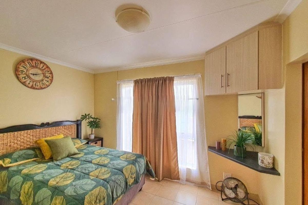 A bedroom featuring tiled flooring, built-in cabinetry, and a built-in vanity shelf, offering a functional layout with natural light from the window.