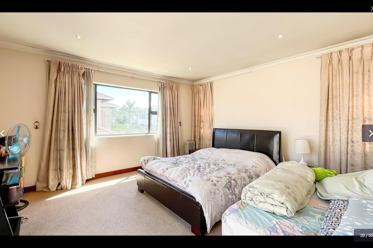 A spacious bedroom featuring neutral walls, carpeted flooring, recessed downlighting, and large windows with curtain rails.