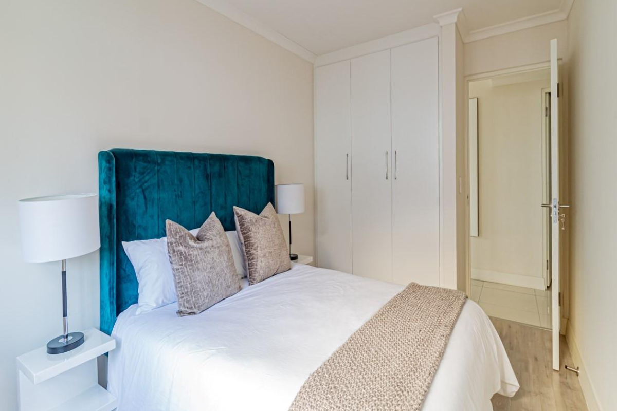 A well-maintained bedroom featuring built-in cupboards and neutral flooring, offering a clean and functional living space.