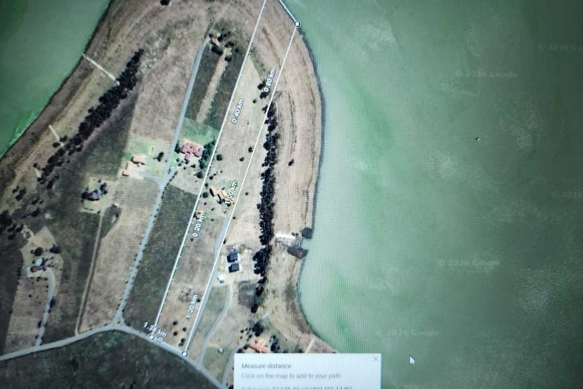 An aerial satellite view showing a large waterfront property parcel with measurement overlays and site boundaries.