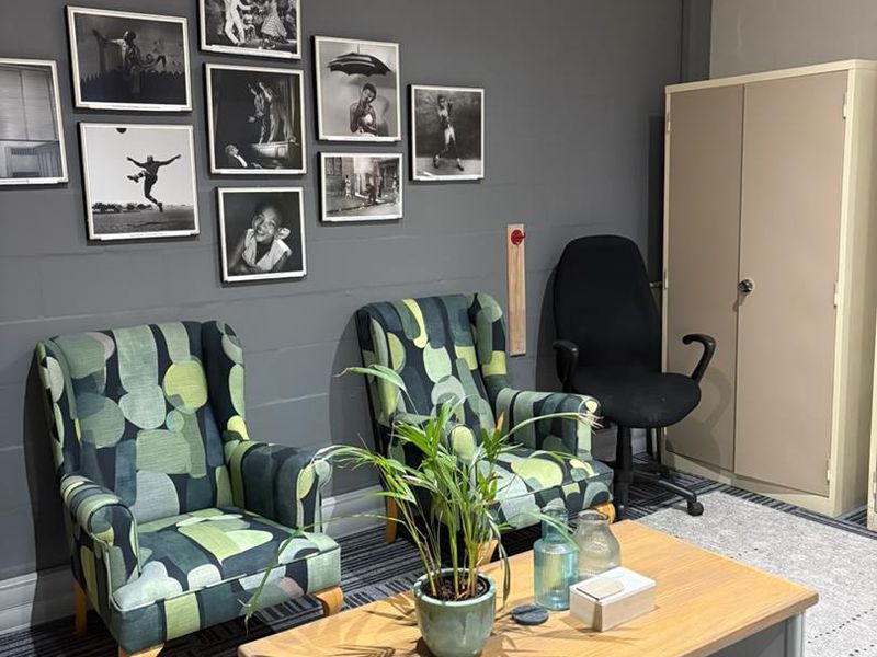 A professional office space featuring a built-in storage cupboard, security camera, and carpeted flooring, suitable for a comfortable work environment.