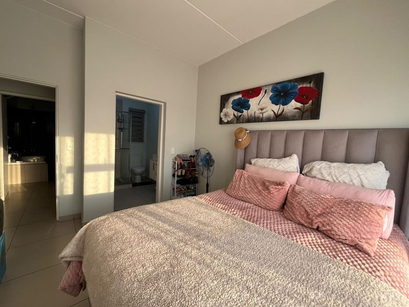 A well-maintained bedroom featuring tiled flooring and direct access to an en-suite bathroom.