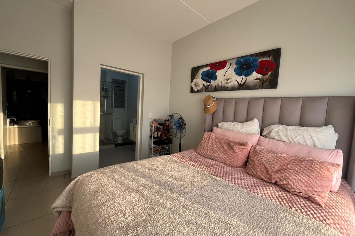 A well-maintained bedroom featuring tiled flooring and direct access to an en-suite bathroom.