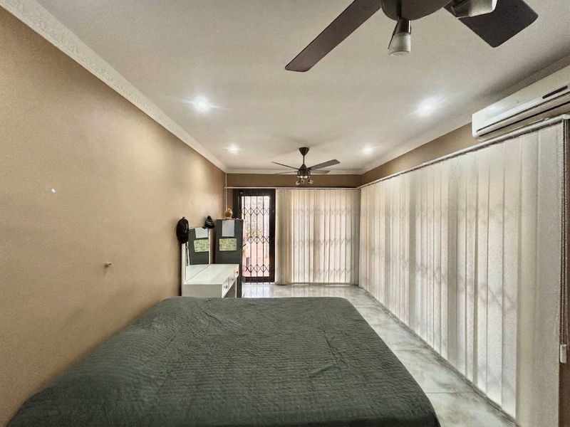 Spacious bedroom featuring tiled flooring, recessed lighting, a ceiling fan, and a wall-mounted air conditioning unit with access to an exterior security gate.
