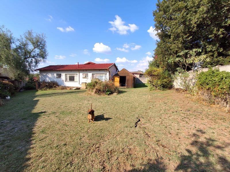 A spacious rear garden featuring a lawn, perimeter wall, and a detached garden shed, providing ample outdoor space.