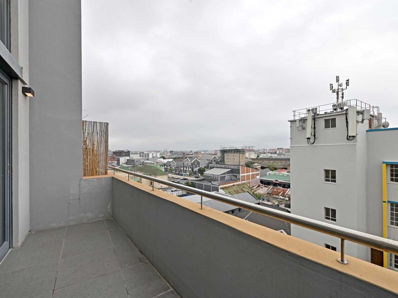 A private penthouse balcony featuring tiled flooring, a stainless steel balustrade, and expansive urban city views.