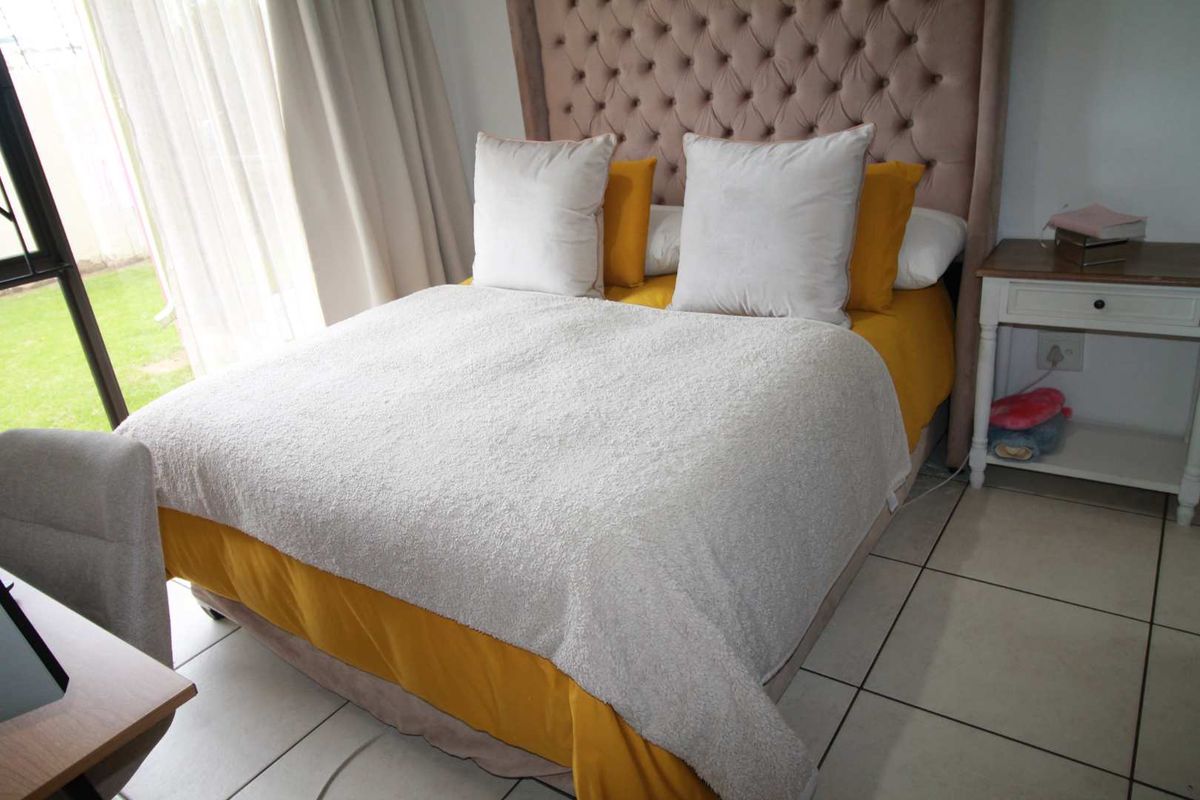 A bedroom featuring tiled flooring and a sliding glass door providing direct access to the outdoor area.